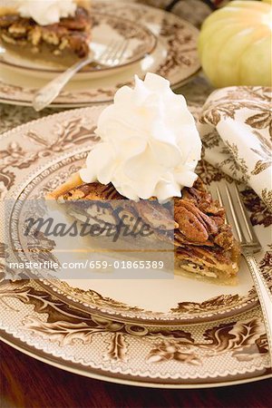 Piece of pecan pie with cream for Thanksgiving