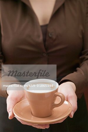 Woman holding cup of cappuccino