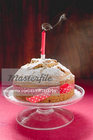 Gâteau d'anniversaire avec un arc rouge et soufflé les bougies