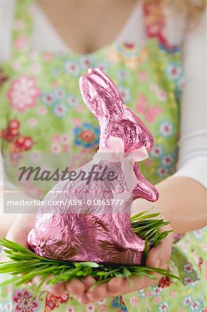 Femme tenant un lapin de Pâques en papier rose