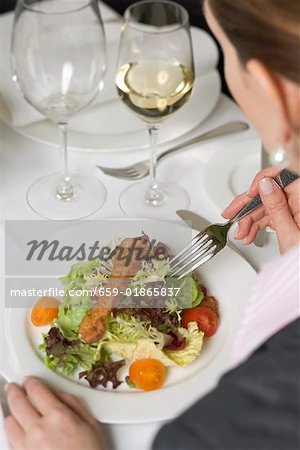 Femme manger salade au restaurant