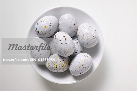 Speckled chocolate eggs in white dish