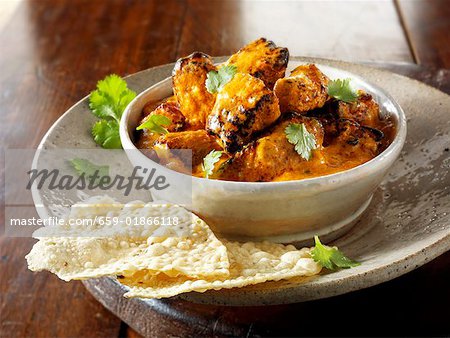 Curry with coriander leaves and poppadoms (India)