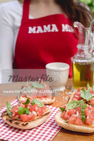 Bruschetta with tomato salsa, woman in background