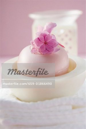 Perfumed soap in soap dish, towels and windlight