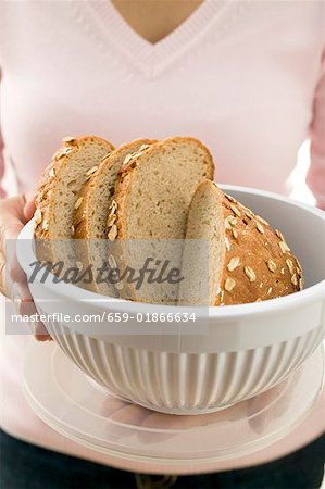 Femme tenant le pain d'avoine dans un récipient alimentaire