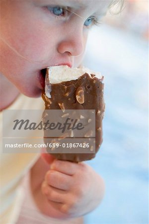 Petite fille mangeant une glace sur un bâton