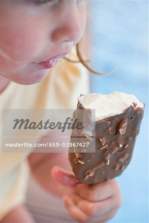 Small girl eating an ice cream on a stick