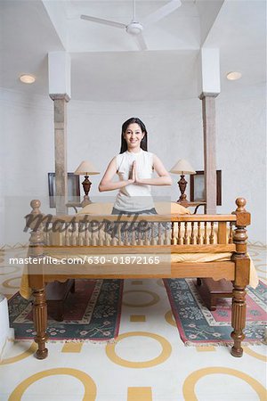 Portrait of a young woman kneeling on the bed in a prayer position