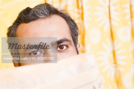 Close-up of a mid adult man with a newspaper