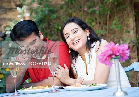 Mid adult couple sitting at a table and having food