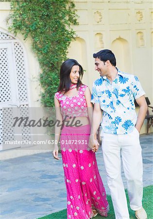 Young couple holding each other's hands and walking