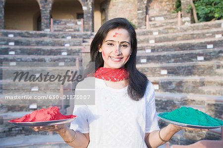Portrait of a mid adult woman holding plates of powder paint, Neemrana Fort Palace, Neemrana, Alwar, Rajasthan, India