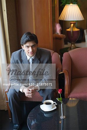 Porträt eines Kaufmanns im Sessel sitzen und Grinsen