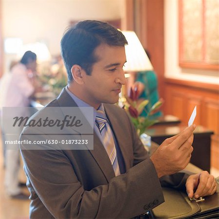 Side profile of a businessman holding a visiting card