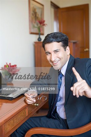 Portrait of a businessman sitting in front of a laptop and smiling