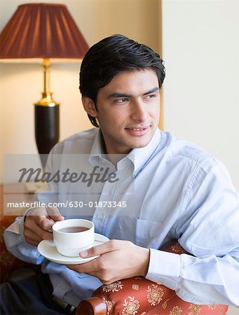 Gros plan d'un jeune homme tenant une tasse de thé