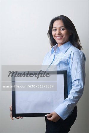 Portrait of a businesswoman holding a blank picture frame and smiling