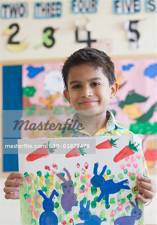 Gros plan d'un écolier montrant une peinture