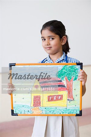 Portrait of a schoolgirl holding a painting and smiling