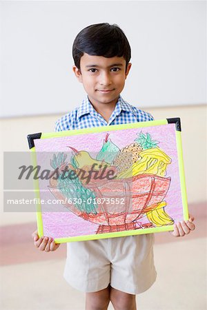 Portrait of a schoolboy holding a painting and smiling