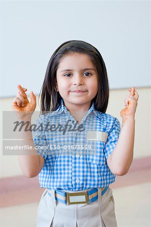 Portrait of a schoolgirl with her fingers crossed