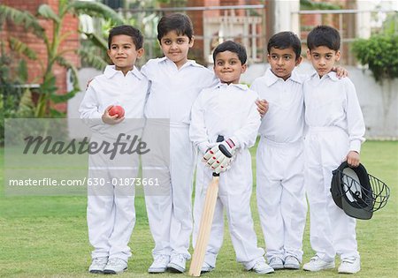 Portrait of five boys standing in a lawn