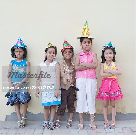 Five girls wearing party hats and standing together