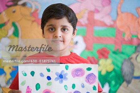 Portrait of a schoolboy holding a drawing