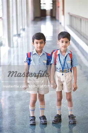 Portrait de deux garçons debout dans un couloir avec main dans la main de l'autre