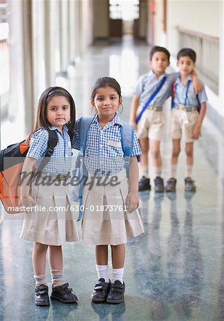 Portrait of two schoolgirls standing in a corridor