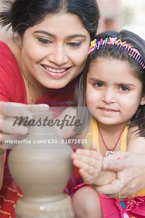 Portrait d'une fille avec son professeur dans une classe de poterie