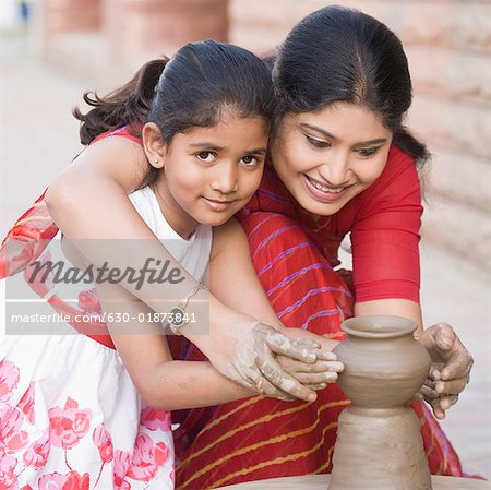 Portrait d'une fille avec son professeur dans une classe de poterie