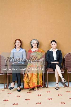 Portrait de trois femmes d'affaires assis sur des chaises