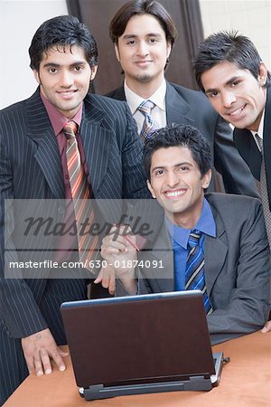 Portrait of four businessmen smiling