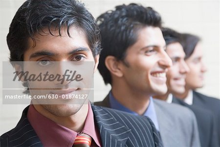 Close-up of four businessmen smiling