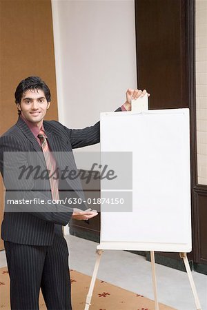 Portrait of a businessman giving presentation near a whiteboard