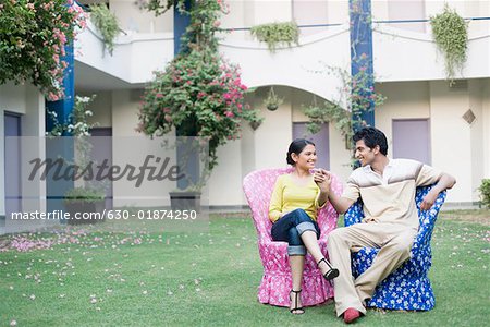 Young couple sitting in a lawn and smiling