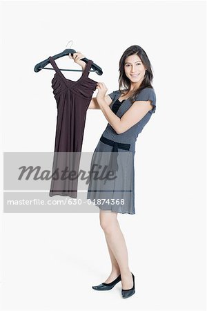 Portrait d'une jeune femme tenant une robe et souriant