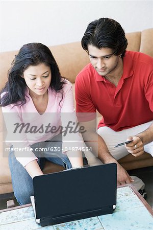 Vue grand angle sur un jeune couple, achats en ligne avec une carte de crédit