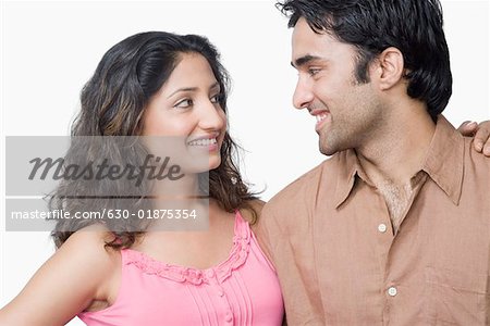 Gros plan d'un jeune couple regardant les uns les autres et souriant