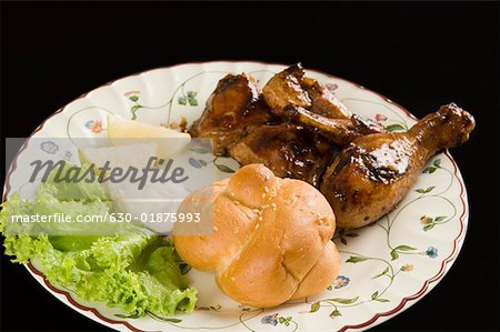 Nahaufnahme von gebratenes Huhn und Brötchen mit Salat in einem Teller