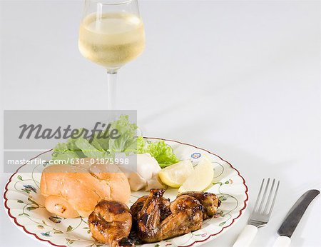 Gros plan de brioche dans une assiette avec un verre de vin et poulet rôti