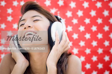 Close-up of a young woman listening to music and smiling