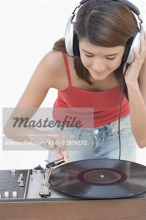 Gros plan d'une jeune femme à l'écoute de la musique et se penchant sur un gramophone