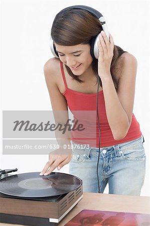 Gros plan d'une jeune femme à l'écoute de la musique et se penchant sur un gramophone