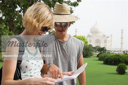 Close-up of a young couple looking at a map, Taj Mahal, Agra Uttar Pradesh, India