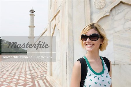 Gros plan d'une jeune femme souriante devant un mausolée, Taj Mahal, Agra, Uttar Pradesh, Inde