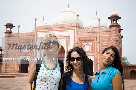 Portrait of three young women smiling in front of a mausoleum, Taj Mahal, Agra, Uttar Pradesh, India