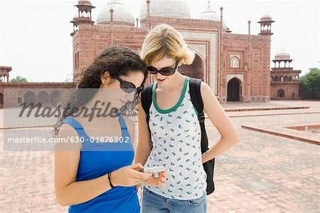 Zwei junge Frauen betrachten einer digitalen Kamera, Taj Mahal, Agra, Uttar Pradesh, Indien